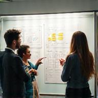 Experts designing HR solutions on a whiteboard